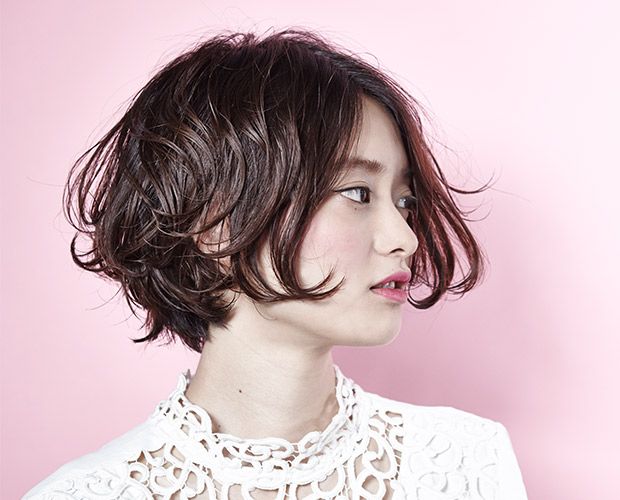 柔らかなウェーブのショートパーマスタイルの日本人女性